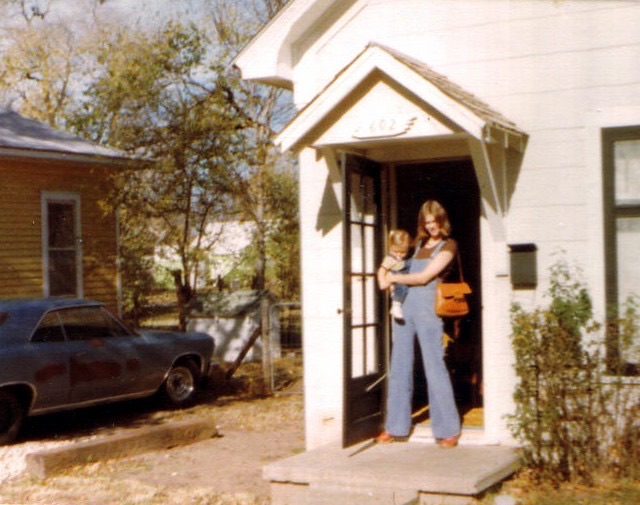 Rebecca holding her baby son Garrett in a doorway, summer 1977