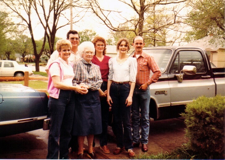 Rebecca with family beside the trucks · c. 1985