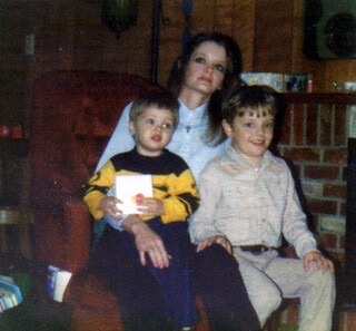 Rebecca with two young boys by the fireplace · c. 1985
